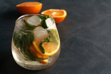 Fresh cocktail with ice cubes, mint and oranges