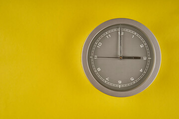clock showing 3:00 on yellow background