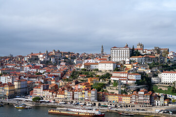 Naklejka na ściany i meble Porto, Portugal, October 31,2020. View on colorful old houses on hill in old part of city and embankment of Douro river in rainy day