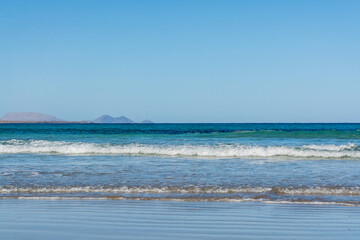 Black lava rocks and water waves of Atlantic ocean, nature landscape on Lanzarote, Canary islands, Spain