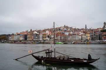 Porto, Portugal, October 31,2020. View from Vila Nova de Gaia on port makers boats and colorful old houses on hill in old part of city. Embankment of Douro river in rainy day
