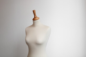 Beige sewing bust with white background wall. Minimalist sewing atelier. Design your clothes.