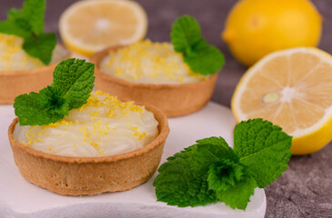 Tartlets with lemon sweet and sour cream and mint. Close-up.