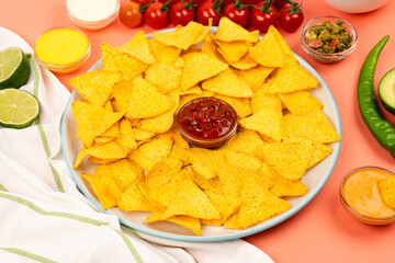 Mexican nachos corn chips on a plate with sauce and vegetables. Mexican cuisine.