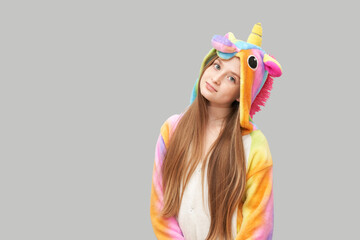 Young pretty girl in unicorn bairthday pajama. Colorful sleep jumpsuit. Happy kid portrait. Fun fashion halloween posing. Kigurumi model. Carnival party teenager. Studio masquerade child © elenavolf