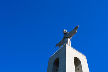 View from below to the monument Cristo Rei, Portugal. Clean blue sky. Sanctuary of Christ the King. Catholic monument.