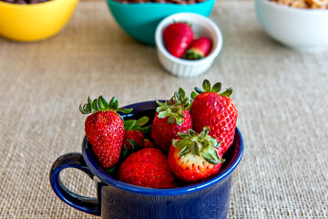 Strawberries in a blue cup, healthy breakfast.