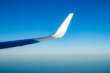Plain wing over blue sky. Flight from Amsterdam to Helsinki.