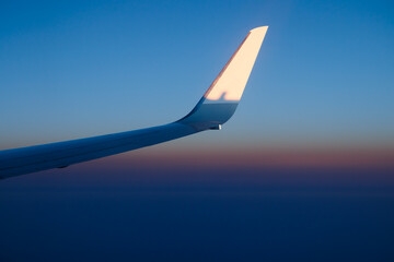 Plain wing against beautiful sunset. Flight from Amsterdam to Helsinki.