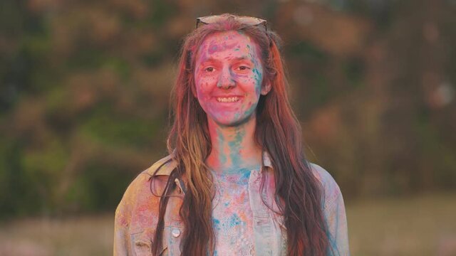 Funny girls are sprinkled with multi-colored powder. Holi holiday.