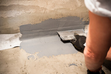 Applying a waterproofing tape to the joint between the wall and the floor. Internal construction works