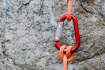 carabiner with rope on rocky background