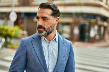 Middle age businessman with relaxed expression standing at the city.