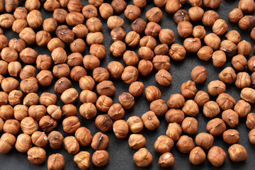 Hazelnuts on a black background. Fresh hazelnut harvest is scattered on black table. 