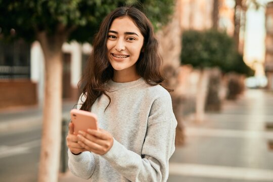 Young middle east girl smiling happy using smartphone at the city.
