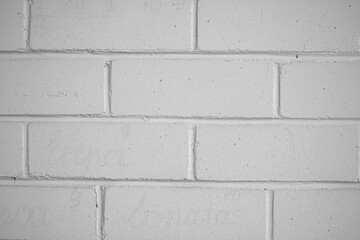 White brick wall texture. Symmetrical geometric shape. Straight lines, block construction, rough surface. Selective focus on the details, blurred background.