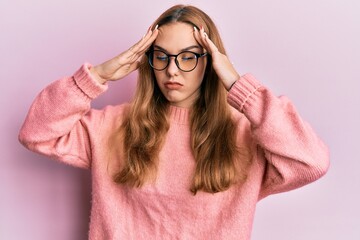 Young blonde woman wearing casual clothes and glasses with hand on head, headache because stress. suffering migraine.