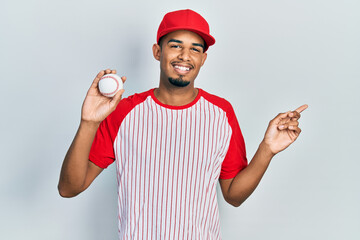 Young african american man wearing baseball uniform shocked covering mouth with hands for mistake. secret concept.