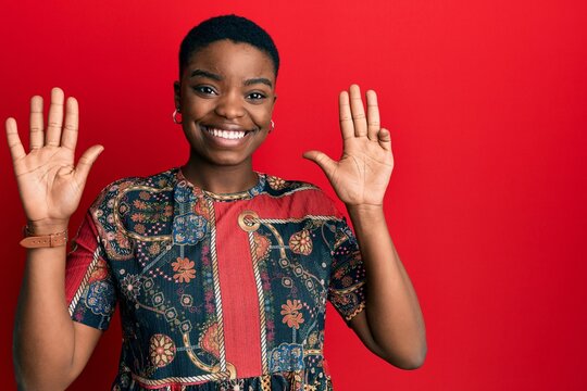 Young african american woman wearing african style showing and pointing up with fingers number nine while smiling confident and happy.