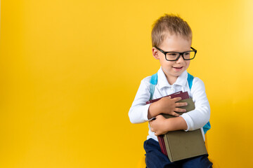 Banner Funny Cute Preschool Child Boy 3-4 years in Glasses hug Book Has Good Idea on Yellow Background Copy Space. Happy Kid Go Back to School, Kindergarten. Success, Winner, Genius, Superhero concept