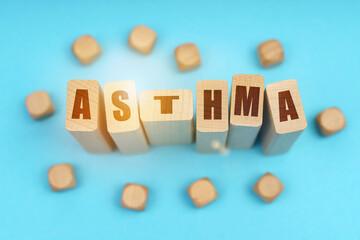 On a blue background, wooden cubes and Jenga with the inscription - ASTHMA