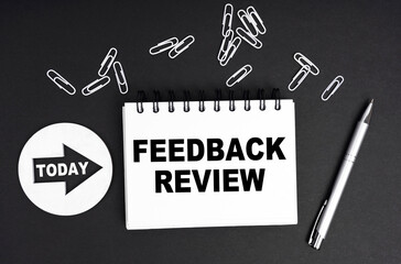 On a black background, a round plate - Today and a notebook with the inscription - FEEDBACK REVIEW