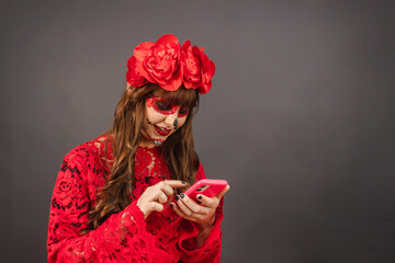 Girl with Day of the Dead makeup using her smart phone.