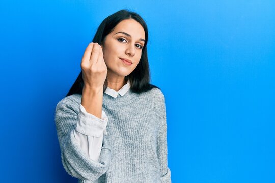 Young hispanic woman wearing casual clothes doing italian gesture with hand and fingers confident expression