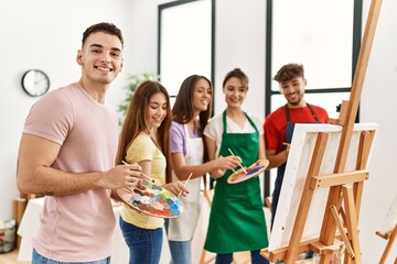 Group of people smiling happy drawing on canvas standing at art studio.