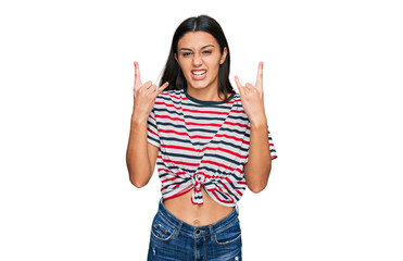 Young hispanic girl wearing casual clothes shouting with crazy expression doing rock symbol with hands up. music star. heavy concept.