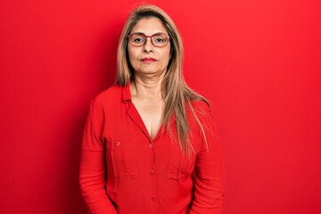 Middle age hispanic woman wearing casual clothes and glasses with serious expression on face....