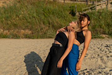 Fototapeta premium Happy young people running on beach and enjoying summer holiday. two young beautiful girls walking on beach