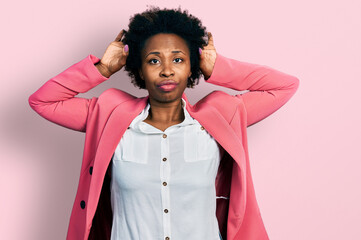 African american woman with afro hair wearing business jacket doing bunny ears gesture with hands palms looking cynical and skeptical. easter rabbit concept.