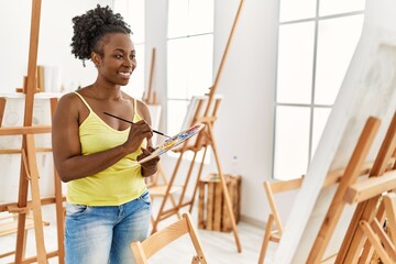 Young african american artist woman smiling happy drawing at art studio.