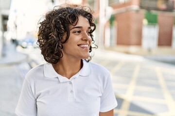 Young latin girl smiling happy standing at the city.