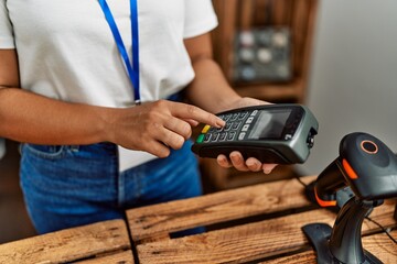 Shopkeeper woman using data phone at clothing store.