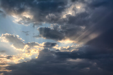 Sunbeams piercing the clouds at dawn.
