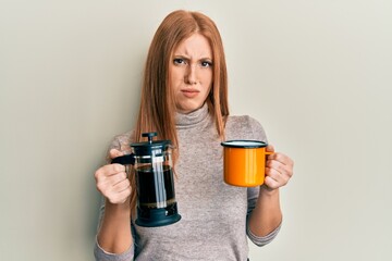 Young irish woman drinking italian coffee skeptic and nervous, frowning upset because of problem....