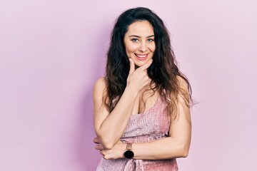 Obraz premium Young hispanic woman wearing casual clothes looking confident at the camera smiling with crossed arms and hand raised on chin. thinking positive.