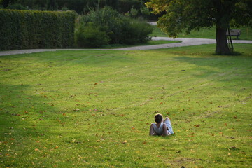 Frau liegt zum Entspannen im Park auf der Wiese