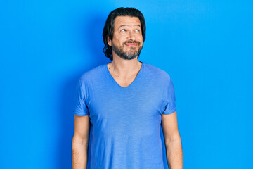 Middle age caucasian man wearing casual clothes smiling looking to the side and staring away thinking.