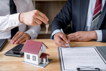 Real estate agent hand over the keys during meeting after signing rental lease contract or sale...