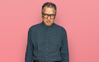 Middle age indian man wearing casual clothes and glasses skeptic and nervous, frowning upset...
