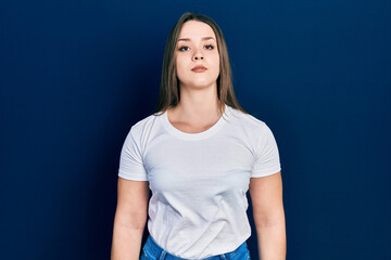 Young hispanic girl wearing casual white t shirt relaxed with serious expression on face. simple and natural looking at the camera.