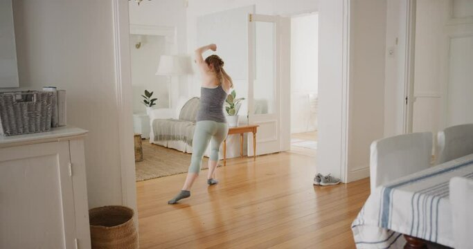 happy young woman dancing at home sliding on floor celebrating on weekend with funky dance moves having fun 4k