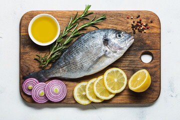 Fresh dorado on a cutting board with lemon and spices.