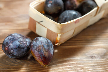 Ripe figs in a wicker basket on a wooden background.