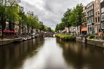 Obraz premium Water canal in Amsterdam, capital and most populous city of the Netherlands. Long exposure photography