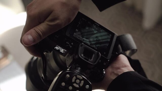 Male photographer takes photographs on a professional camera with flash.