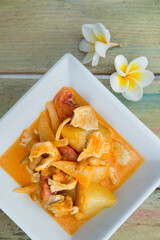 Yellow curry with chicken on wooden background. Copyspace. Traditional thai food